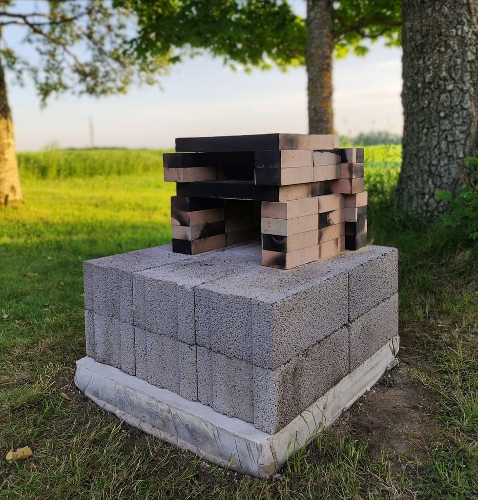 An outdoor wood fired pizza oven with a poured concrete slab as a foundation